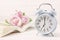 Blue retro alarm clock with book and pink pastel roses