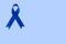 Blue ribbon on blue background with copy space. Colorectal Cancer Awareness. Colon cancer of older person. World diabetes day