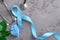 Blue ribbon, stethoscope and rose on concrete background, prostate cancer awareness concept.