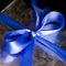 Blue Ribbon Tied in a Bow on Silver Gift.