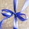 Blue Ribbon Tied in a Bow on Silver Gift.