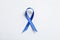 Blue ribbon on white background, top view. Cancer awareness