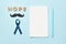 Blue ribbons with mustache, word hope and notepad with pen . Prostate Cancer Awareness. Men health awareness. Movember concept