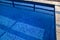 Blue ripped water in swimming pool in tropical resort with edge of pavement. Part of Swimming pool bottom background.