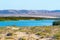 Blue river and flock of birds, sand dunes with native plants, mountains