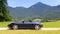 Blue roadster Porsche Boxster 986 with Bavarian Alps panorama at German Alpine Road