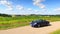 Blue roadster Porsche Boxster 986 with corn field panorama at Romantic Road