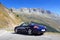 Blue roadster Porsche Boxster 986 with mountain panorama at Furka Pass road.