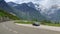 Blue roadster Porsche Boxster 986 with mountain panorama and hairpin curve at Grossglockner High Alpine Road