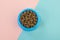 Blue round feeding bowl with dark brown heart shaped pet kibble