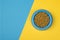 Blue round feeding bowl with pet dried food on a blue and yellow background