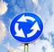 Blue roundabout crossroad road traffic sign against blue cloudy