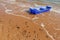 Blue rowboat on the beach with lapped small wave.