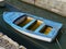 A blue rowing boat with a lot of rain water