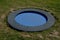 Blue rubber surface of the playground with a lawn and circular trampolines sunk into the terrain. children can jump and do somersa