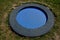 Blue rubber surface of the playground with a lawn and circular trampolines sunk into the terrain. children can jump and do somersa