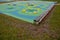 Blue rubber surface of a playground with yellow scoops and colored spots in the frost of human footprints. raised lenses such as b