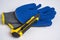 blue rubberized work gloves and a stationery knife lie on a white background