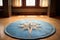 a blue rug with a compass design in the middle of a light-toned hardwood floor