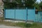 Blue rural iron gate and part of the fence