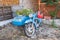 Blue Russian motorcycle, Soviet motorcycle Izh Jupiter with helmet, filled with blooming flowers decoration