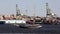 Blue sail tour boat CLIPPER CITY, passing on background of Red Hook docks on Brooklyn side, New York, NY