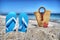 Blue sandals and straw bag by the shore