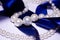 Blue satin ribbon with pearl jewelry. Luxurious decoration. For jewelry sites, blogs about fashion, style, jewelry. Snow-white