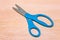 Blue scissors. Object is on wood background without shadows.