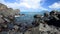 Blue sea and blue sky with changing white clouds. Small islands and rocks.