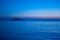 Blue sea at sunset with island and moon