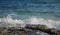 Blue sea view with white wave splashing over beach rock. Volcanic seaside during high tide