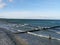 Blue sea and waves with white whitecaps wash around the groyne near Zingst