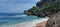 Blue sea white sand beach with beautiful towering hills and rocks