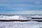 Blue sea with wooden breakwaters, blue cloudy sky, seascape