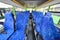 Blue seats for passengers in saloon of empty city bus