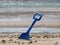 Blue shovel in the sea sand