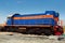 Blue shunting diesel locomotive with an orange stripe.