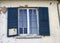 Blue Shutters Glass Window Stucco House