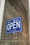 Blue sign on the glass door of the clothing store - open