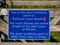 A blue sign marking the most northerly point of UK National Cycle Route 1, in Skaw on the island of Unst in Shetland, Scotland, UK