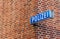 Blue sign with \\\'Police\\\' in German written on it hanging on a brick wall