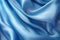 Blue silk fabric texture background. Beautiful blue satin textile texture with folds. Smooth elegant abstract background