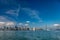 Blue skies fill the picture of the San Francisco skyline on the left and the bay bridge on the right with the moon in the