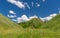 Blue skies, white clouds and hills overgrown with wild grasses