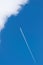 Blue sky and airplane with contrail - vertical shot