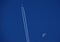 Blue sky, airplane and waning moon