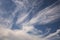 Blue sky background with big white tiny stratus cirrus striped clouds