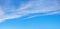 Blue sky background with floating cirrostratus clouds at the upper half