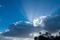 Blue sky background with fluffy white clouds and rays of sunlight